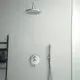 Duschbereich mit verchromter Badearmatur von Ideal Standard, bestehend aus einer Deckenbrause und einem Handbrausekopf, an glatt verputzter Wand ohne sichtbare Fliesen.
